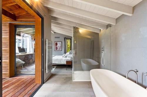 une salle de bain avec baignoire et une chambre dans l'établissement Casa Madera - Villa au bord de la mer, à Lecci