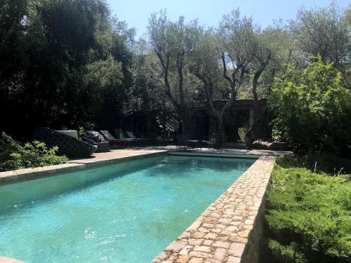 - une piscine dans une cour arborée dans l'établissement Casa Madera - Villa au bord de la mer, à Lecci