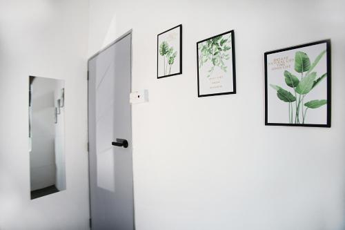 a bathroom with three pictures on the wall and a mirror at HangoutSpacez Queensbay at Bayan Lepas Penang in Bayan Lepas