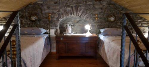 a bedroom with two beds and a lamp on a night stand at La casa della Cindy in Dervio