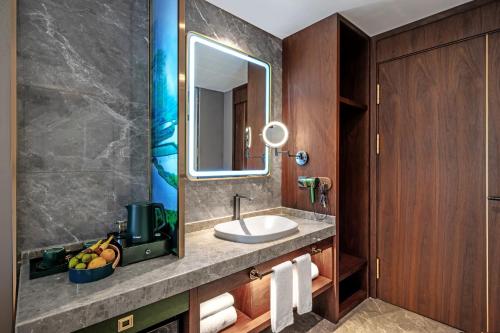 a bathroom with a sink and a mirror at Nostalgia S Hotel Kunming Old Street 时光漫步S酒店 昆明火车北站穿心鼓楼地铁站店 Free fresh ground coffee,Free laundry service in Kunming