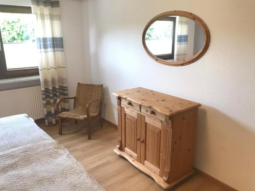 een slaapkamer met een spiegel en een houten kast bij Maxi-Apartment Bodanum - mit eigener Terrasse - naturnahe Ortsrandlage - VDSL - 10 min zum Nürburgring in Bodenbach