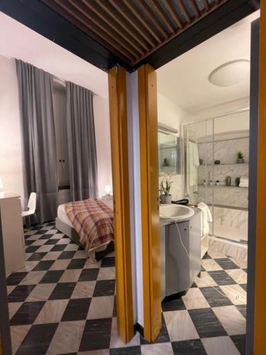 een slaapkamer met een bed en een badkamer met een wastafel bij Happy Family Apartments Cathedral in Genua