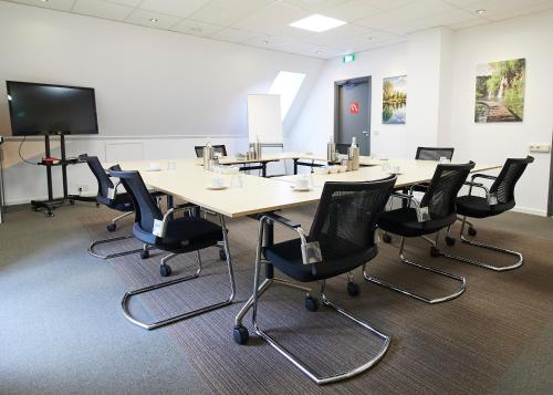 a conference room with a long table and chairs at Hotel Erve Hulsbeek in Oldenzaal