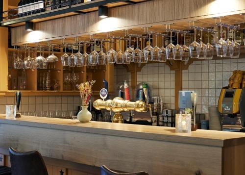 a counter in a restaurant with glasses on the wall at Hotel Erve Hulsbeek in Oldenzaal