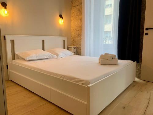 un grand lit blanc dans une chambre avec une fenêtre dans l'établissement ApartHotel Riviera - BALCON BARLA - Old Port PLace du Pin, à Nice