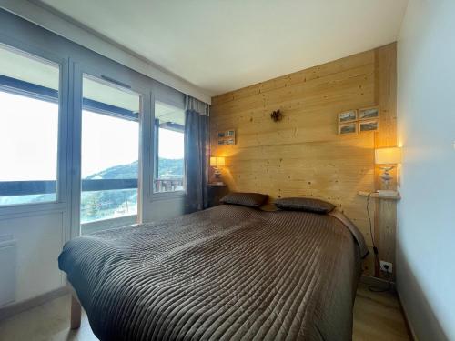 une chambre avec un lit et deux fenêtres dans l'établissement Homency - Résidence L'Ours Blanc 852, à L'Alpe-d'Huez