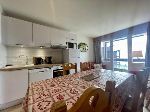 une cuisine avec une table et une cuisine avec une salle à manger dans l'établissement Homency - Résidence L'Ours Blanc 852, à L'Alpe-d'Huez
