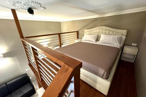 a bedroom with a bed and a wooden staircase at La Maison Du Relaxment in Foggia