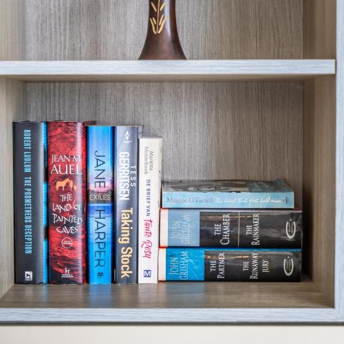 a group of books sitting on a shelf at Avalon by the Sea - A Breath of Oceanfront Luxury in Sliema