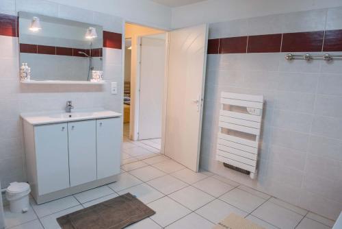 a white bathroom with a sink and a mirror at Gites de france 3 epis 8 personnes a malbouzon in Malbouzon