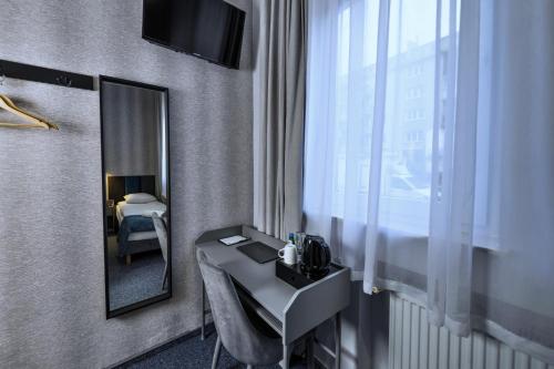 a bathroom with a sink and a mirror and a bed at Elegant Apartments in Poznań