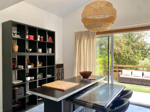 une salle à manger avec une table et une grande fenêtre dans l'établissement Jolie villa avec jardin terrasses jacuzzi 15mins plages - MONTPELLIER, à Pignan