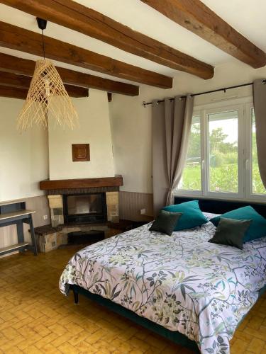 - une chambre avec un grand lit et une cheminée dans l'établissement Gîte de L'Enclose La Barre de Monts 85, à La Barre-de-Monts