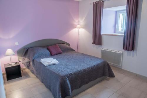 una camera da letto con un letto con un piumone blu di Gites de france a veyres a Saint-Laurent-de-Veyrès