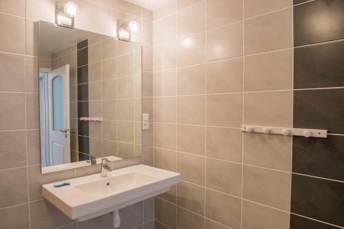 un bagno con lavandino e specchio di Gites de france a veyres a Saint-Laurent-de-Veyrès