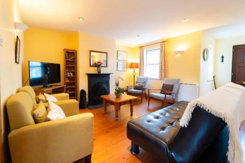 a living room with a couch and a fireplace at Dingle Town Cottage - Tigh Peig in Dingle
