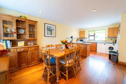 a kitchen with a wooden table and wooden floors at Dingle Town Cottage - Tigh Peig in Dingle