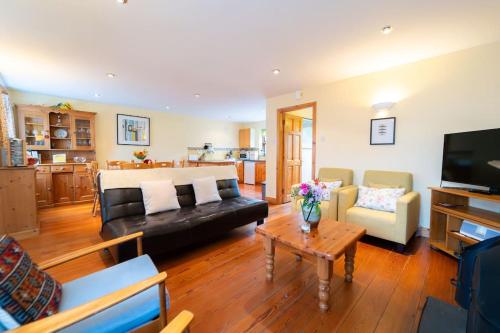 a living room with a black couch and a table at Dingle Town Cottage - Tigh Peig in Dingle