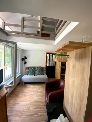 a living room with a couch and a stairway at Appartement au cœur des Préalpes in Séranon