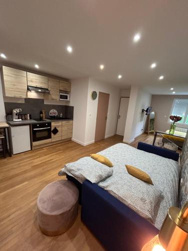 une chambre avec un lit bleu et une cuisine dans l'établissement Entre gare et centre-ville, à Issoudun