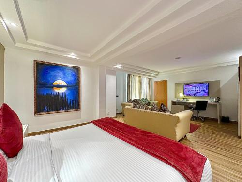 a bedroom with a large bed and a living room at Victoria Crown Plaza Hotel in Lagos