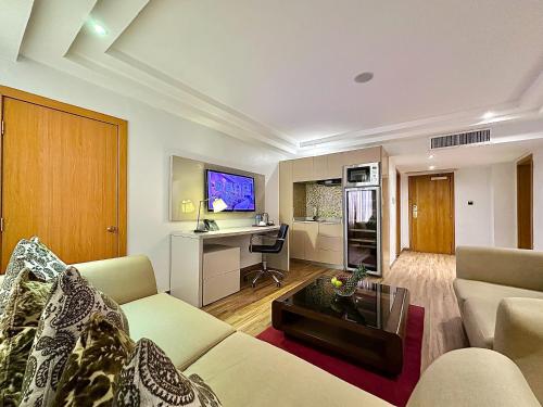 a living room with a couch and a table and a desk at Victoria Crown Plaza Hotel in Lagos