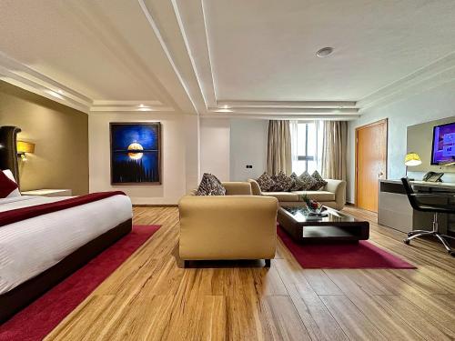 a hotel room with a bed and a living room at Victoria Crown Plaza Hotel in Lagos