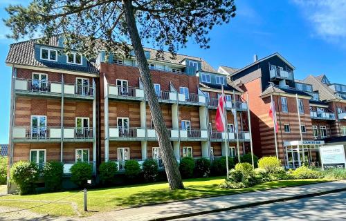a large brick building with flags in front of it at Country Hotel Timmendorfer Strand in Timmendorfer Strand