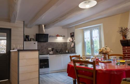 une cuisine avec une table et un chiffon rouge dans l'établissement L'oustal de pagat, à Les Hermaux