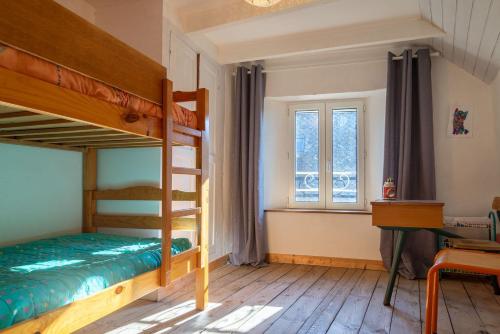 une chambre avec deux lits superposés et un bureau dans l'établissement L'oustal de pagat, à Les Hermaux