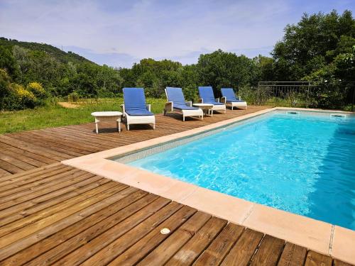 une piscine avec des chaises bleues et une terrasse en bois dans l'établissement Domaine Hemmitage, à Salernes