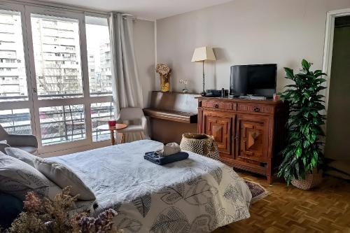 un salon avec un lit et une télévision à écran plat dans l'établissement Levallois-Perret -Porte de Paris, à Levallois-Perret