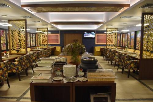 a dining room with tables and chairs in a restaurant at Hotel Pushpak in Bhubaneshwar