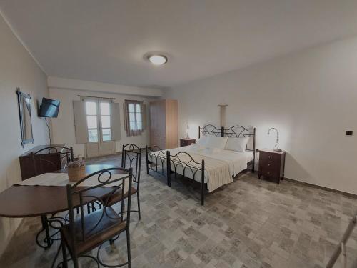a bedroom with a bed and a table and chairs at Paesino in Kionia