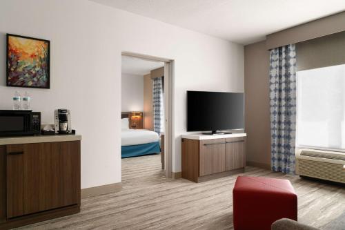 a hotel room with a bed and a flat screen tv at Hilton Garden Inn Rock Hill in Rock Hill