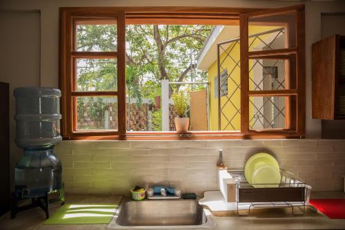 a kitchen with a sink and a window and a sink at La Bicicleta Hostal in Managua