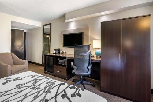 a hotel room with a bed and a desk with a computer at Sleep Inn Clearwater-St Petersburg in Clearwater