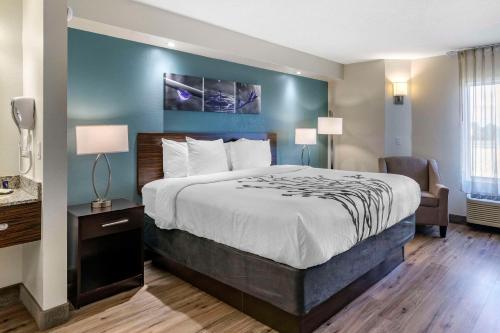 a hotel room with a bed and a chair at Sleep Inn Clearwater-St Petersburg in Clearwater
