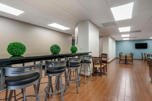 a bar with stools in a room with a tv at Sleep Inn Clearwater-St Petersburg in Clearwater