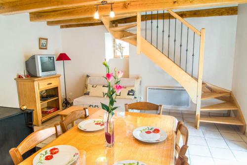 une salle à manger avec une table et des chaises et un escalier dans l'établissement Gîte Gîte 2/4 personnes à La Grandville, à La Salle-Prunet