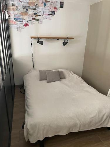 une chambre avec un lit blanc dans une pièce dans l'établissement Studio cosy proche de Versailles, à Fontenay-le-Fleury
