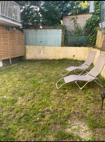 2 chaises longues assises dans l'herbe dans une cour dans l'établissement Studio cosy proche de Versailles, à Fontenay-le-Fleury