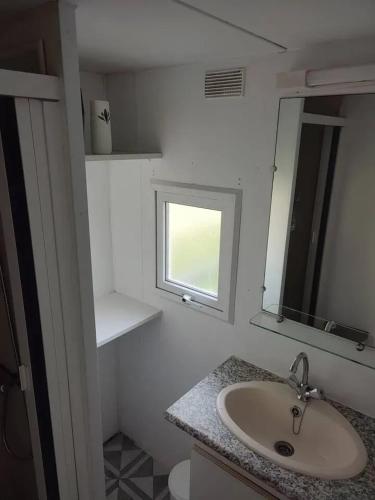 une salle de bain avec un lavabo et un miroir dans l'établissement Bungalow cosy à Commequiers avec piscine partagée, à Commequiers