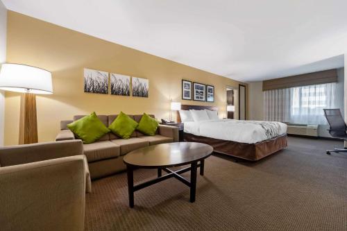 a hotel room with a bed and a couch at Sleep Inn & Suites Bismarck I-94 in Bismarck