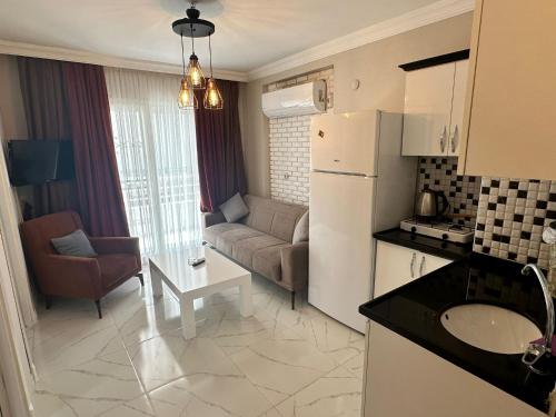 a kitchen and living room with a refrigerator and a couch at İlkay Apart in Kaleköy