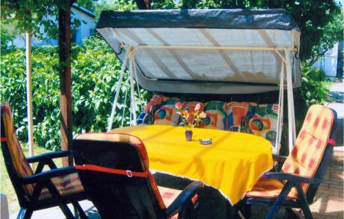 a table with a yellow table cloth and chairs at Holiday Home Am Wiesengrund V in Löcknitz