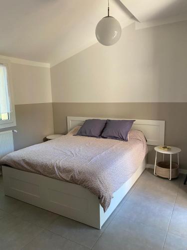 une chambre avec un lit avec une couette violette dans l'établissement La Margoline, à Montagnac