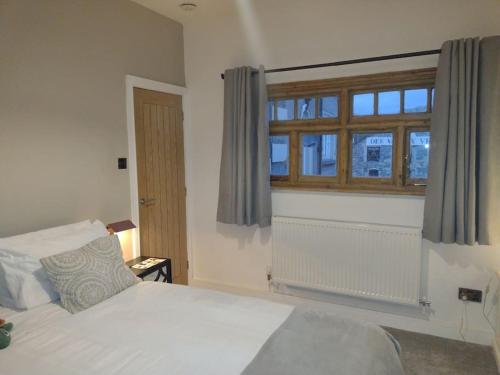 a bedroom with a white bed and a window at Castell Bach in Llangollen