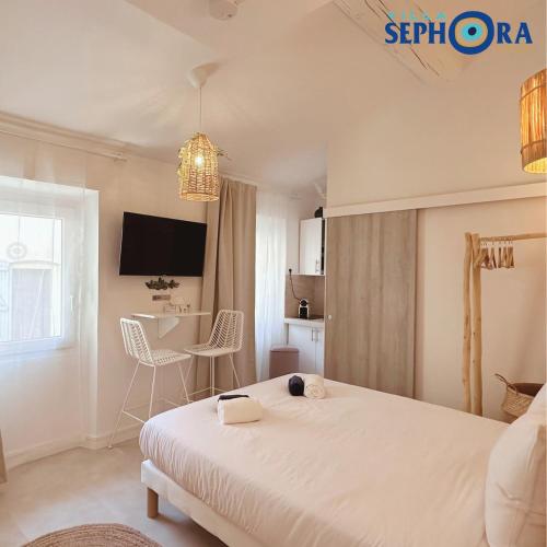 une chambre avec un lit et une table avec des chaises dans l'établissement VILLA SEPHORA CANNES, à Cannes